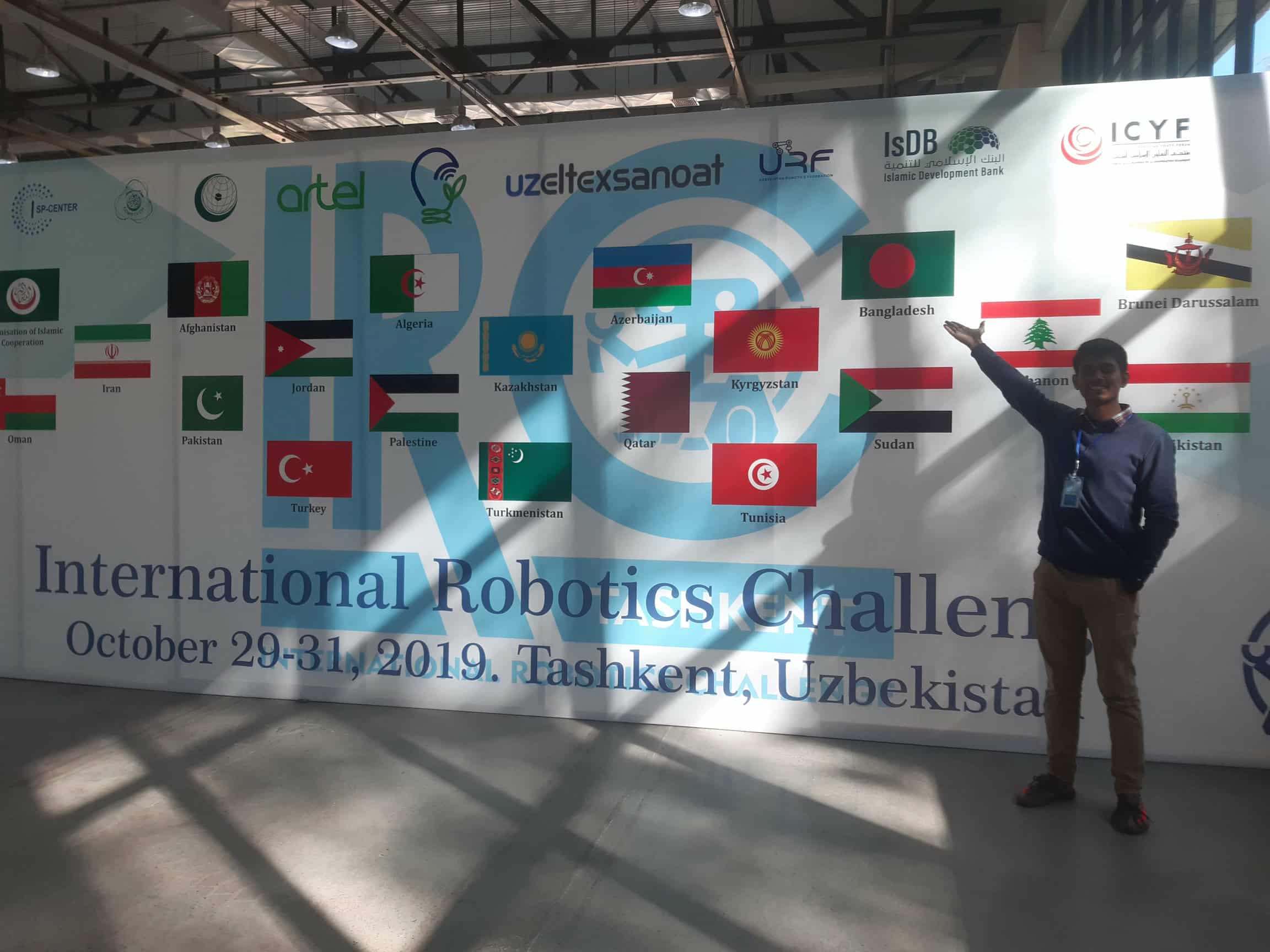 Participant beside the International Robotics Challenge event banner